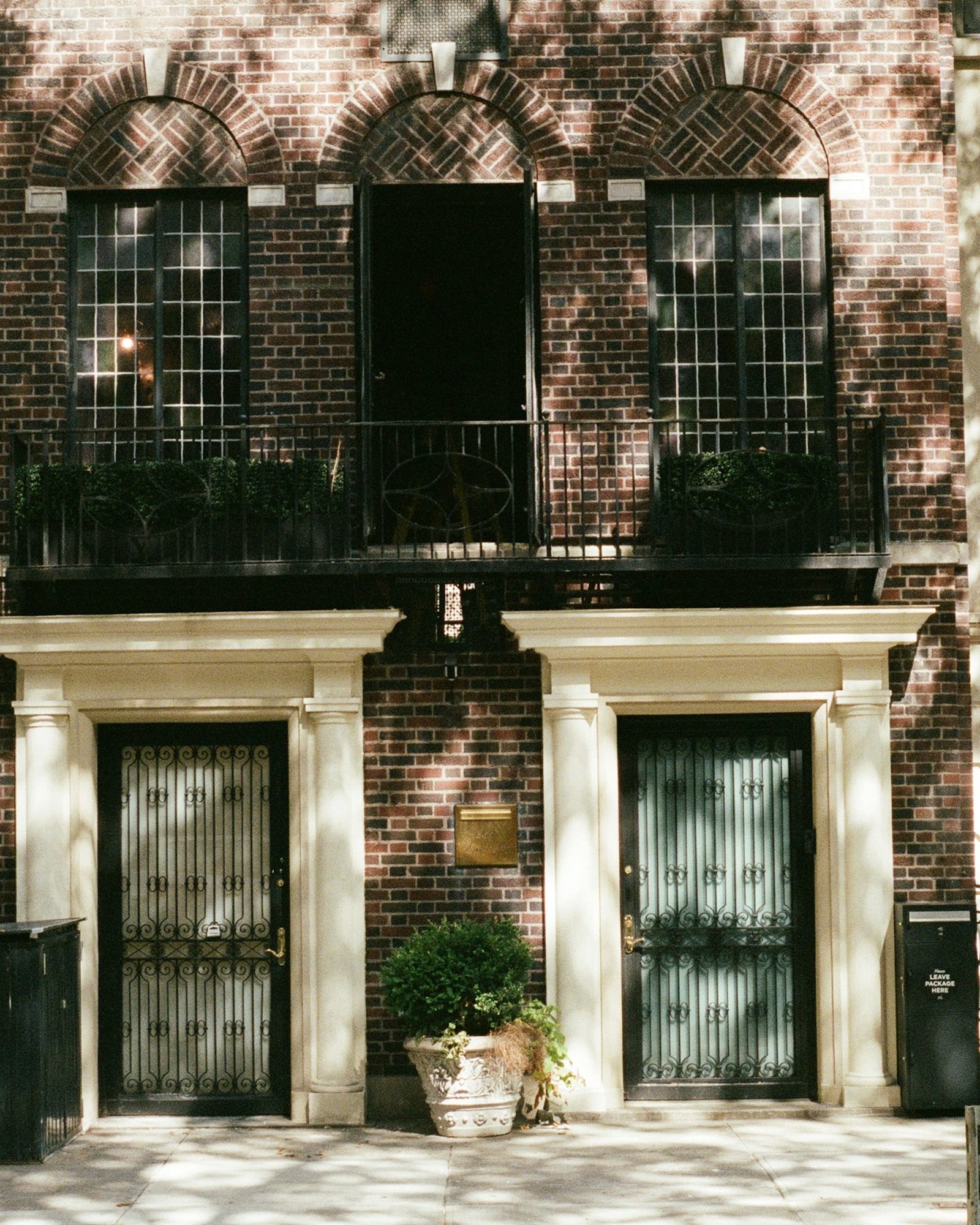 A brick townhouse with an arched doorway and iron railings